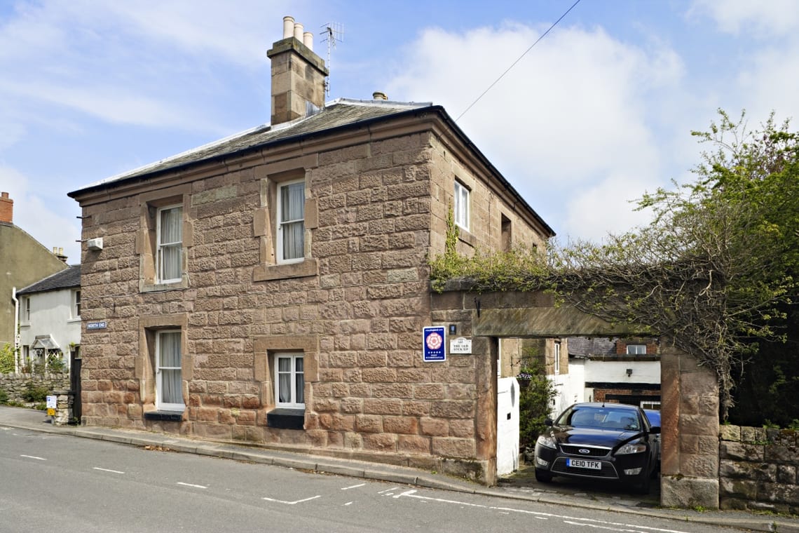Pierre exterior de Le Ancien Verrouille-Fiça dans Wirksworth avec son paon d'entrée