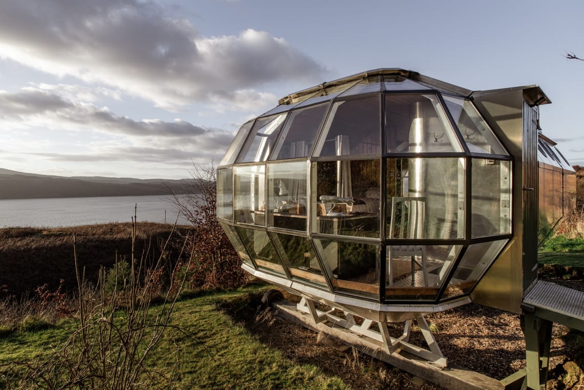 A metal and glass cabin next to the sea