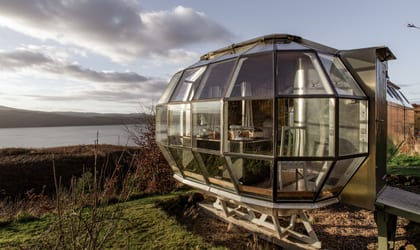A metal and glass cabin next to the sea
