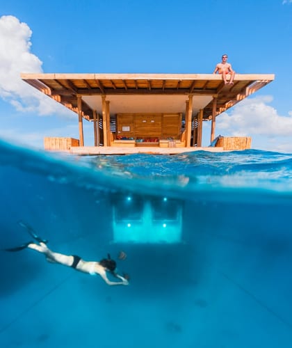 A room built on water showing you how it looks above the water level and underneath it below the water level