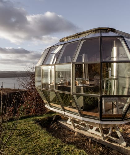 A metal and glass cabin next to the sea
