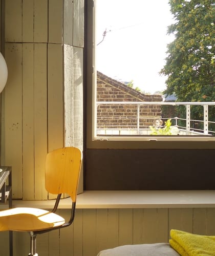 Desk and chair next to a window seat and open window