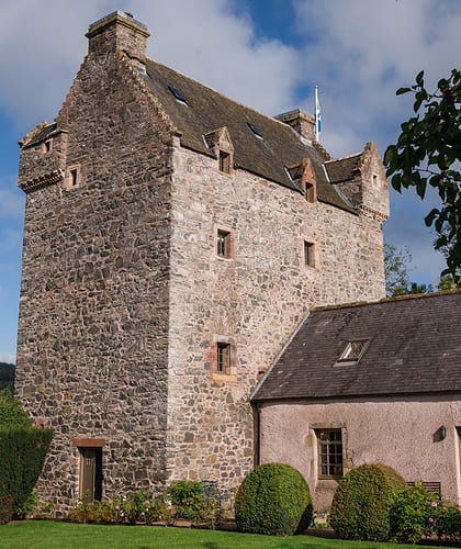 An old sandstone building with a medium tower at one end