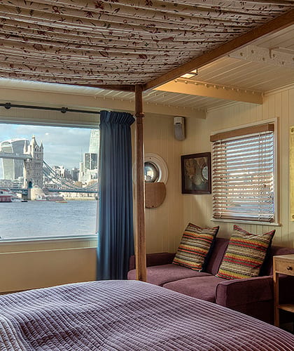 Inside a bedroom on a house boat on the River Thames with a view of Tower Bride